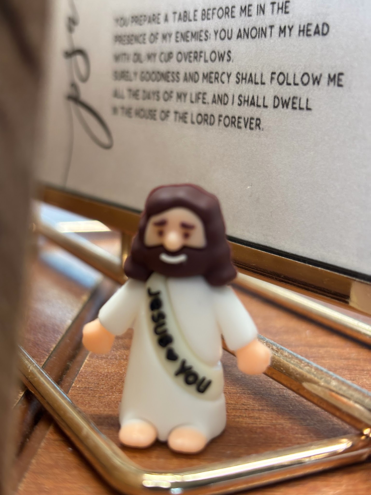 A small Jesus figurine beside a “Jesus loves you” message.